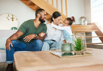 Obraz premium Bonding, laughing and love with family hugging on sofa in living room of home together for growth. Development, excited or funny girl child in apartment with mom and dad for safety, security or trust