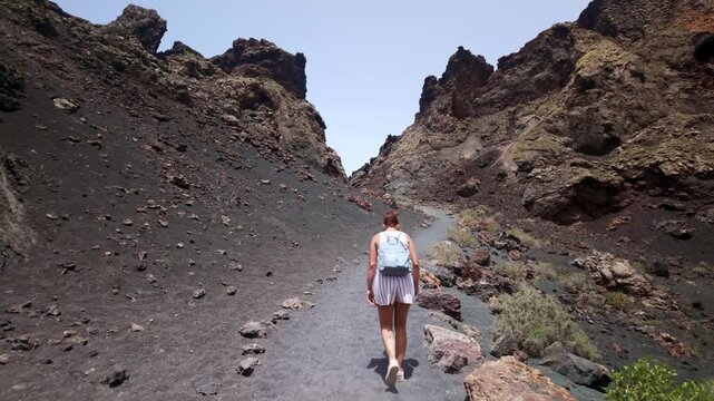 Woman hiking inside El Cuervo volcano in Lanzarote, Spain