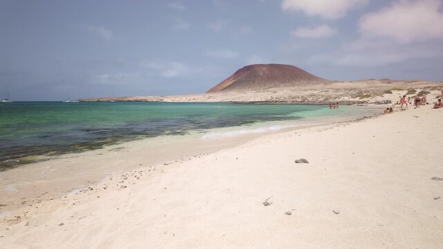 People swimming on volcanic beach in La Graciosa island