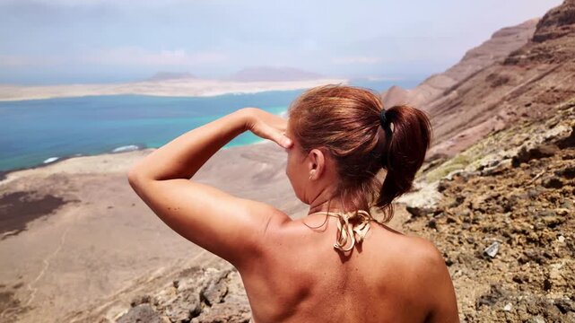 Woman from behind watching Risco beach in Lanzarote