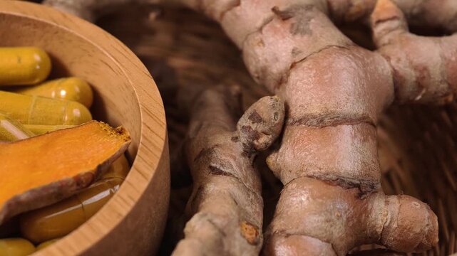 Turmeric powder capsules with turmeric roots in a basket