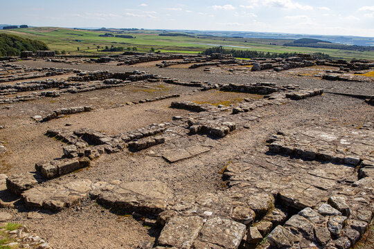 View of the ancient stone foundations of Vindolanda Roman fort overlooking the rolling green hills of the English countryside Hexham, England, United Kingdom.