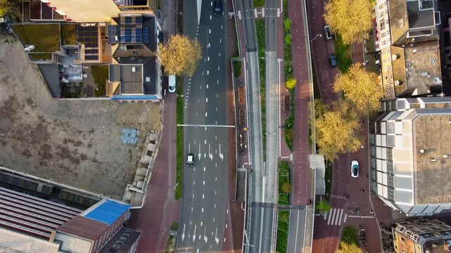 Urban arterial road with multi lane traffic and dedicated cycle lanes in Arnhem Gelderland Netherlands showing intersection control lane markings and mixed mobility infrastructure drone top down