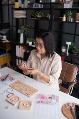 Fototapeta premium Mature asian woman&nbsp;making handmade jewellery accessories handcraft hobby