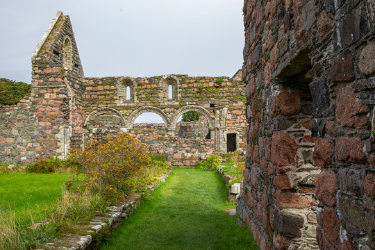 View of the Iona Nunnery ruins featuring ancient stone walls and arched windows set within a grassy courtyard Baile Mor, Scotland, United Kingdom.