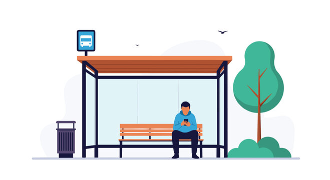Young man sitting on a wooden bench inside a bus stop shelter while using his smartphone during a wait in the park.
