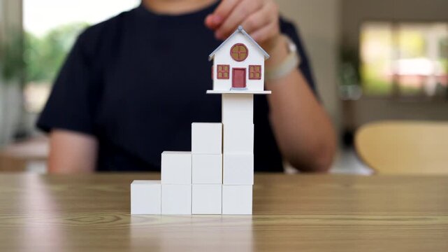 Small House Model on Top of White Block Stairs for Real Estate Growth and Property Investment Success Concept
