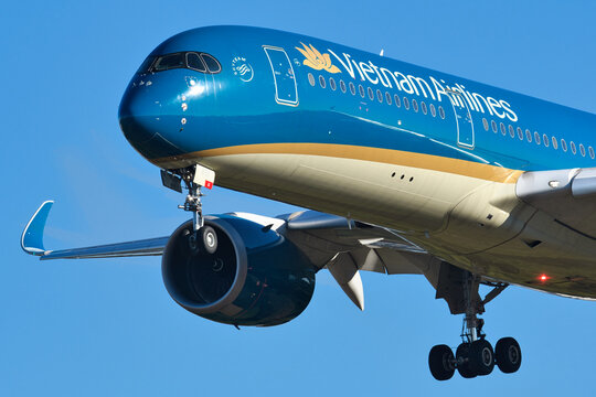 Vietnam Airlines Airbus A350-900 (VN-A899) passenger aircraft close-up nose and winglet view on final approach with landing gear deployed.