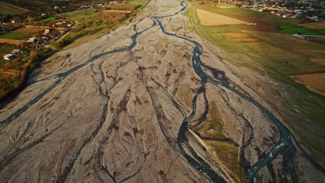 Aerial Landscape Overview. High Altitude Image Displaying Land Features And Water Flows. Topdown Perspective Capturing Soil Patterns And Water Erosion Marks Across Fields