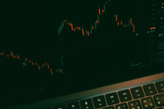 Trading Chart with Red and Green Candles on Dark Laptop Screen, Stock Market Financial Analysis Concept