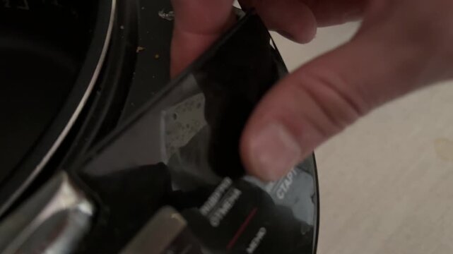 Person pressing button on multicooker control panel close up at home, starting cooking program, kitchen appliance use concept