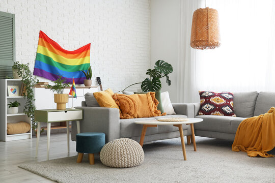 Interior of living room with LGBT flag, sofas and tables