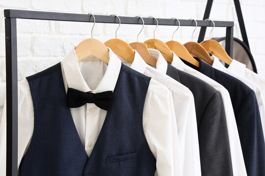 Men's suits with bow tie hanging in boutique
