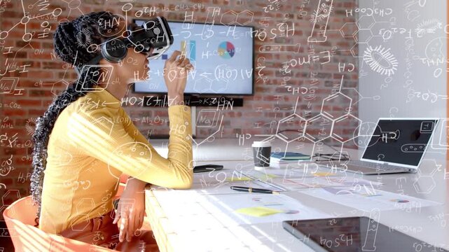 Woman adjusting VR headset, gesturing at table and managing animated tech charts to review data