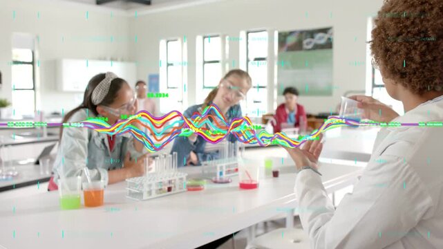 Teacher turning, holding blue beaker showing demo for science while waveform moving across midline