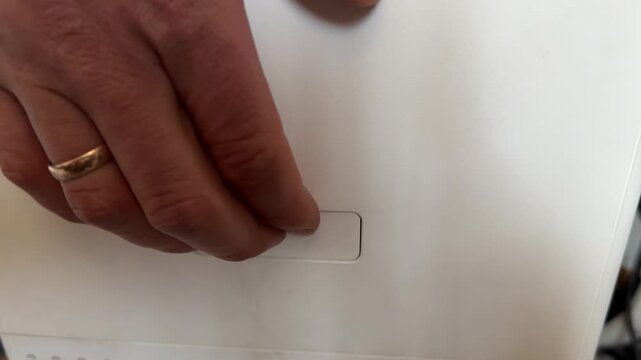 Hand pressing release button to detach compartment from air purifier for filter replacement, home appliance maintenance concept