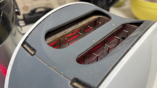 toaster with glowing heating elements preparing bread, kitchen appliance in use, breakfast cooking concept, home lifestyle scene