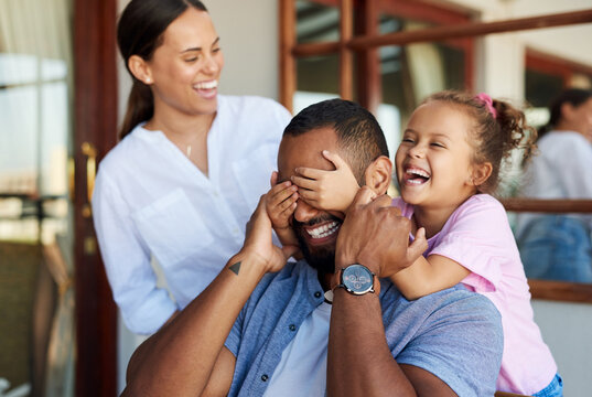 Parents, father and child with peekaboo in home, weekend bonding and laughing for happy relationship. Family, people and girl with surprise game for smile, love and playful interaction for connection