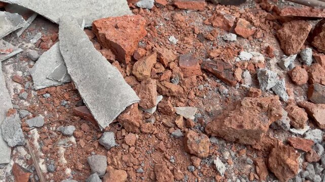 Construction debris and broken red bricks on ground