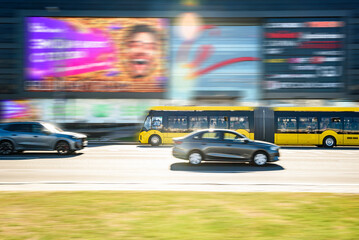 Fototapeta premium A yellow city bus driving along Minsk avenue road. Public transport in Belarus.