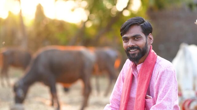 young indian farmer sitting with bull at indian rural village