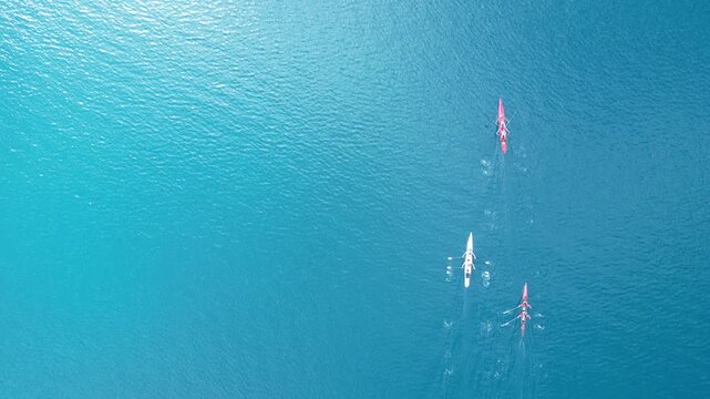 Top Down Aerial View of Rowing Boats Competing in a Race on Turquoise Sea. High quality 4k footage
