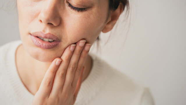 Young woman suffering from toothache