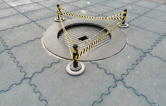 A damaged outdoor trampoline on a public playground restricted with yellow warning tape. Concept of safety hazards for kids, broken play equipment, risk prevention, and urgent maintenance needed.