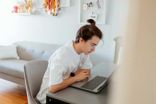 Focused person working on laptop in modern home office
