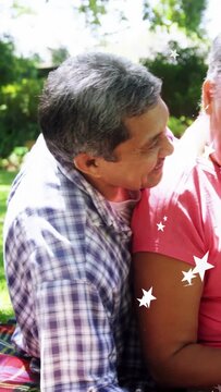 Vertical video: Senior couple leaning close on blanket as stars prompt nuzzling for health bonding