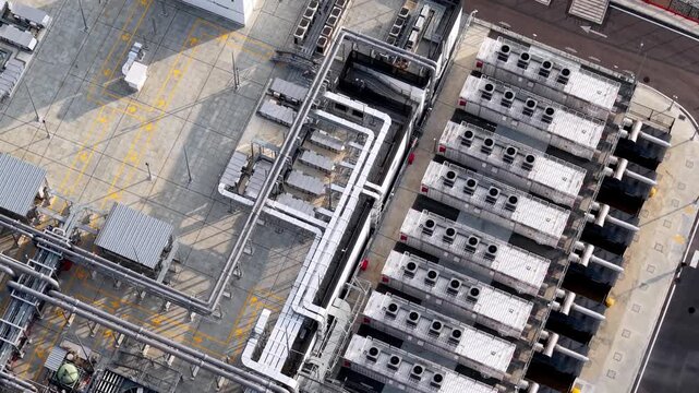 Aerial view of industrial rooftop complex. Rows of cooling units stand in grid pattern