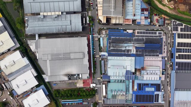 Top down drone shot of Pekan Nanas industrial park showing factories, solar panels, roads and parking lots.