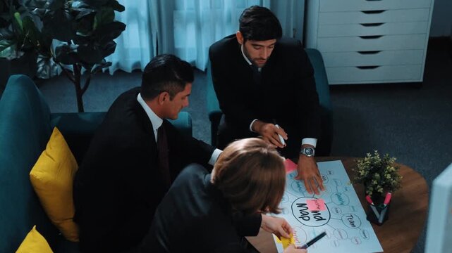 Top view of skilled businessman write marketing idea and drawing mind map while project manager explain financial strategy at meeting room. Professional startup team brainstorm idea. Directorate.