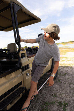 young boy leaning from safari vehicle, Okavango Delta, Botswana, Africa