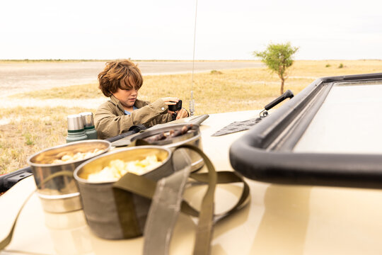 young boy preparing to use camera, Okavango Delta, Botswana, Africa