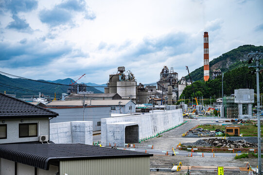 東日本大震災の教訓を経て建設された防潮堤と、復興が進む沿岸部の工場地帯の俯瞰。 / Overview of a newly built seawall and an industrial area undergoing reconstruction after the tsunami.