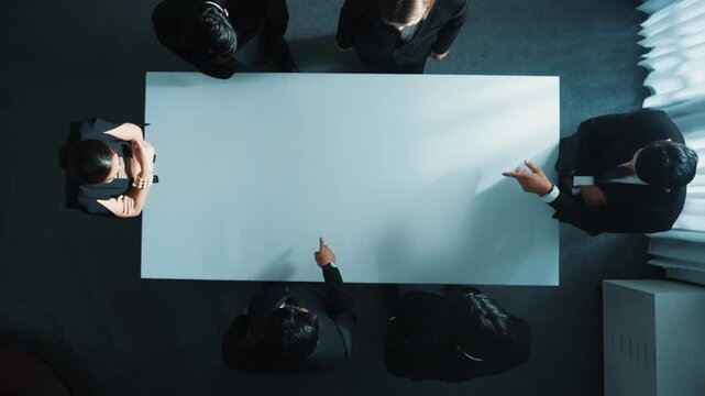 Top down aerial view of smart cooperate businessman discussing about marketing strategy. Diverse business group brainstorming idea startup project and financial plan at meeting room. Directorate.