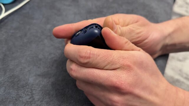 Hands opening case of old button mobile phone close up, vintage electronics repair and retro communication device concept