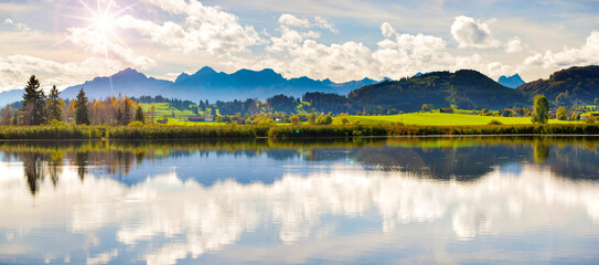 Im Allgäu spiegeln sich die Berge auf der Wasseroberfläche des Sameister Weiher bei Roßhaupten © Wolfilser