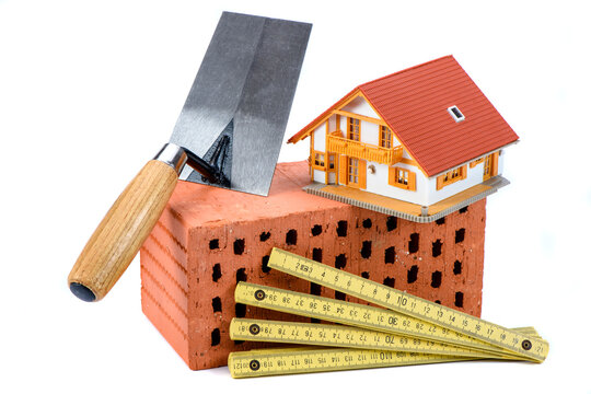 Symbolbild f&uuml;r Wohnungsbau mit Ziegelstein und Werkzeug