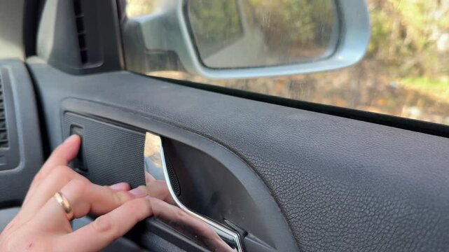 Finger pressing car power window switch, raising and lowering side glass automotive control concept