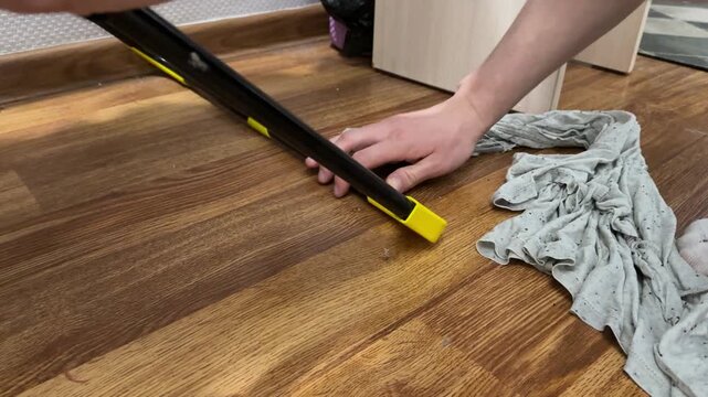 man moving clothes drying rack across floor at home, household task, organization, daily routine, domestic activity, real people