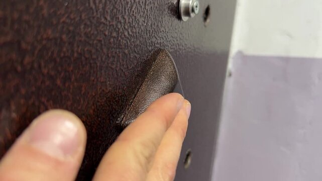 Person pressing button to open metal entrance door in apartment building close up, access control action, entry system use, everyday routine