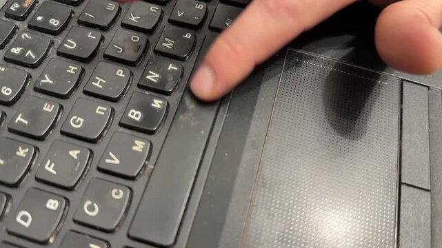 Hand pressing space bar on old laptop keyboard, using outdated portable computer for work and technology concept
