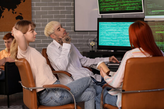 Team of young programmers working in office at night