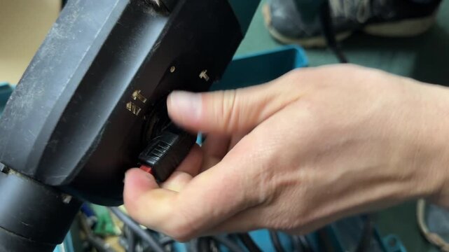 Hand changing operating mode on rotary hammer drill control switch, power tool adjustment for construction work, professional hardware concept