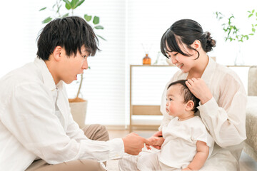 Fototapeta premium A couple, family, parent and child comforting their baby in the living room.