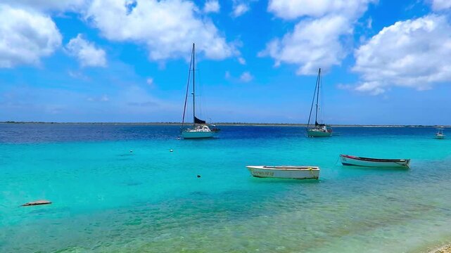 Sailboats, yachts and small fishing boats in tropical caribbean paradise. Sailing boats near the beach, serene footage from exotic vacation. Beach and sea on the exotic island.