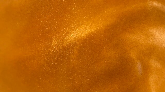 Gold particles floating background, liquid gold, abstract golden backdrop. Beautiful metallic yellow texture, swirls moving. Metallic paint close-up. Art Wallpaper waves surface 