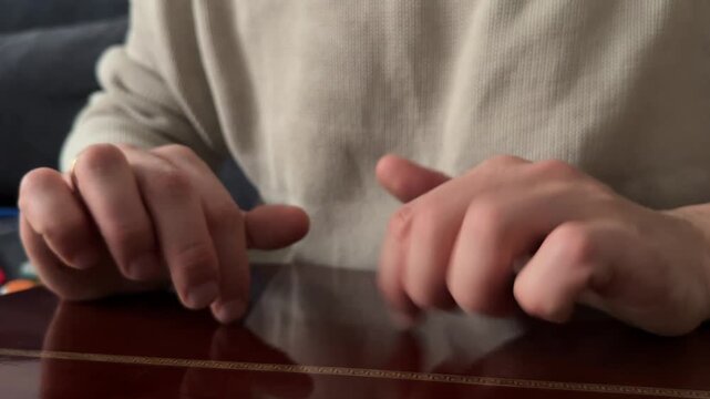 Person tapping fingers on acoustic guitar body close up at home, producing rhythmic percussion sound, improvised music activity, creative hobby concept